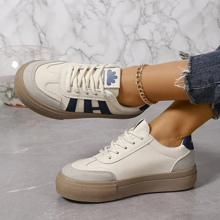 Białe damskie sneakersy retro ze sznurowaniem na jasnym tle